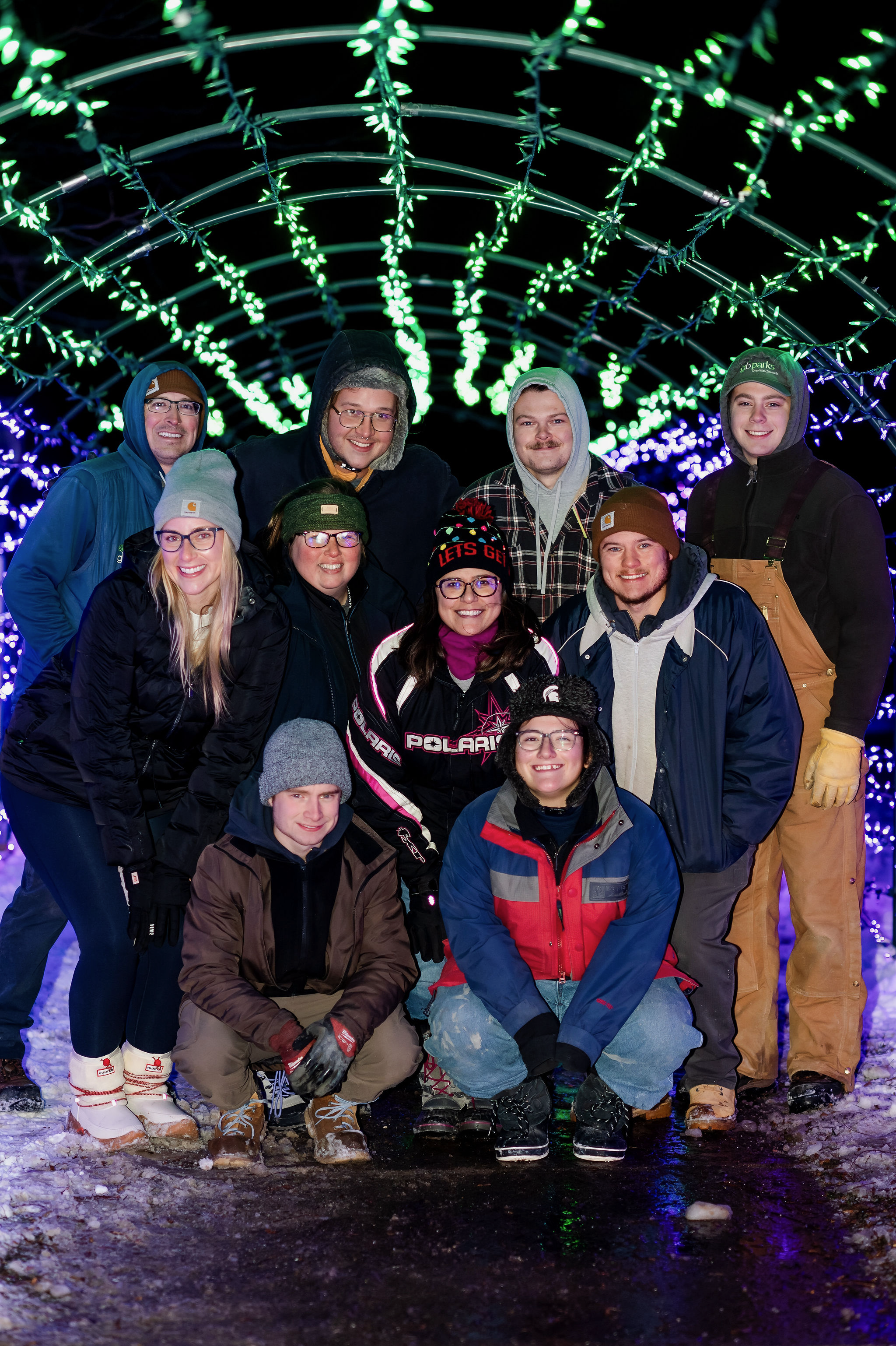 Group photo of park workers under holiday lights